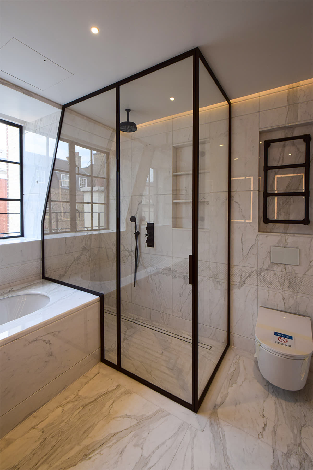 bronze frame bespoke shower enclosure under eaves next to a bath