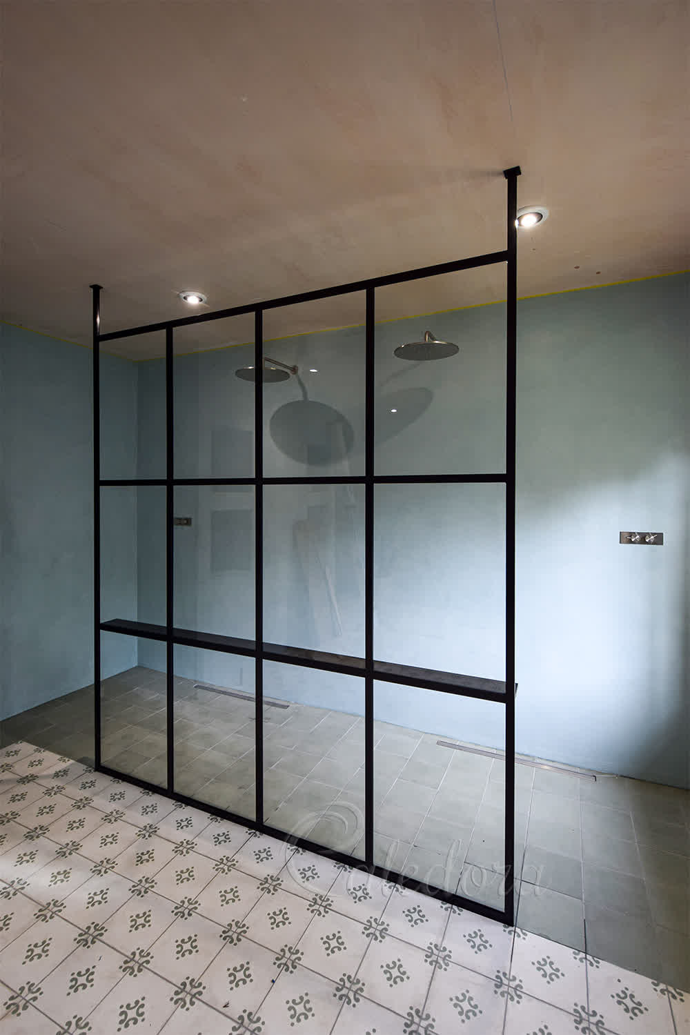 Black grid walk-in shower screen with full height design and microcement walls in Lewes