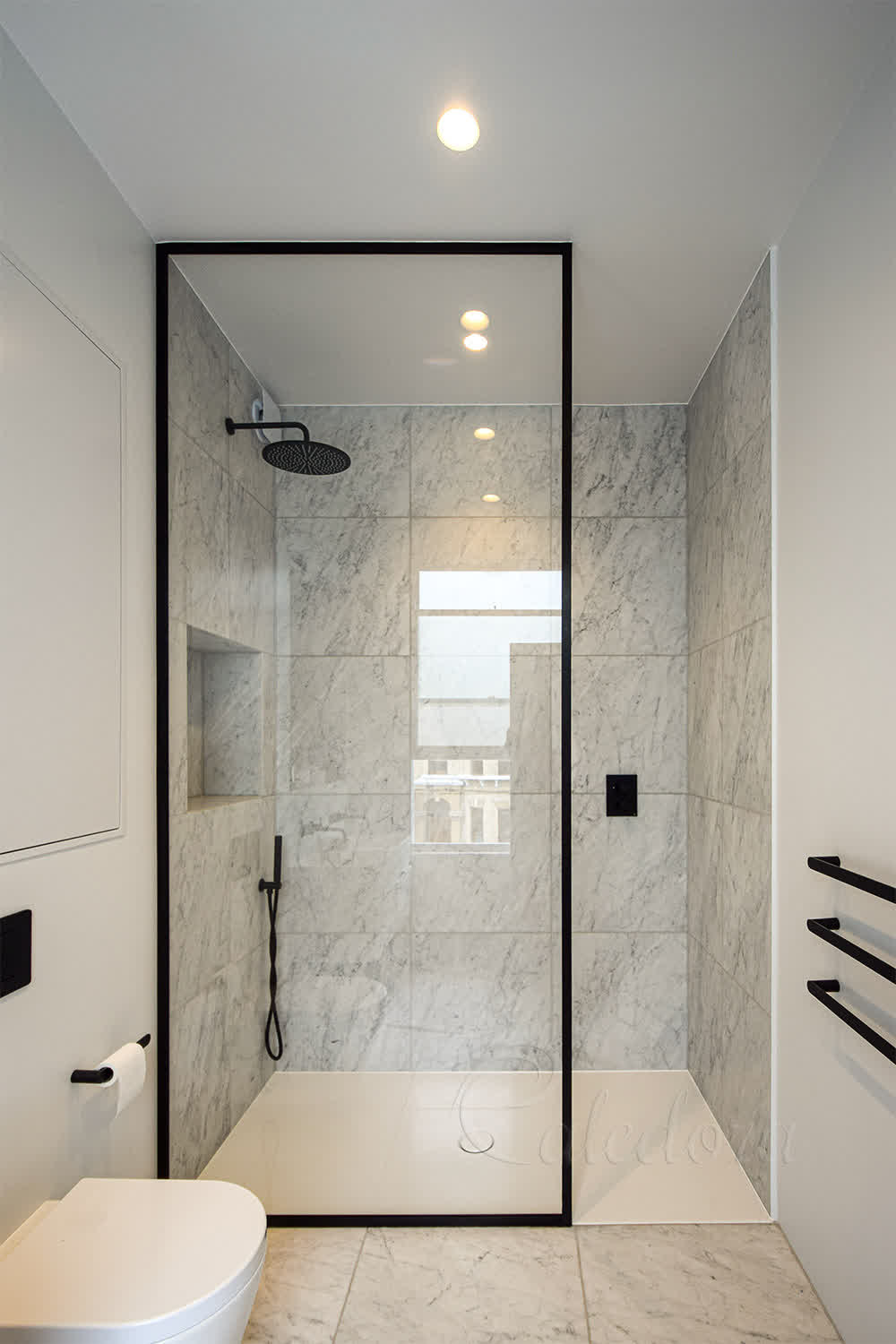 Walk-in black framed shower screen with Ultra Clear glass and marble wall background