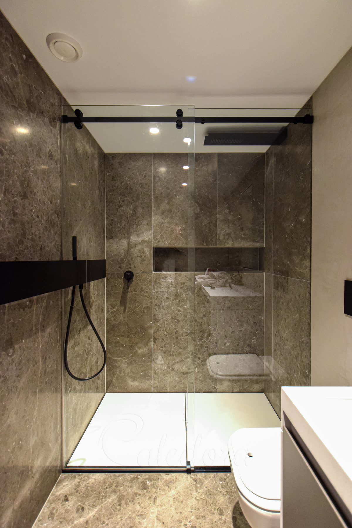 Black sliding shower door with custom cut-out for wall shelf