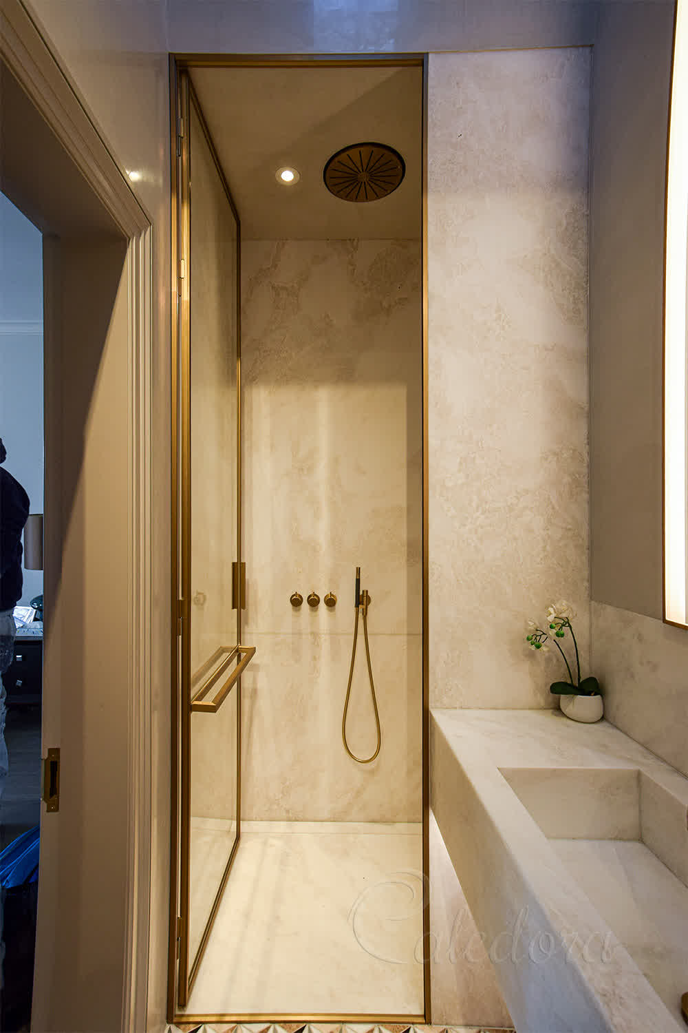 Custom L-shaped brass handle and towel rail fixed to ultra clear shower glass