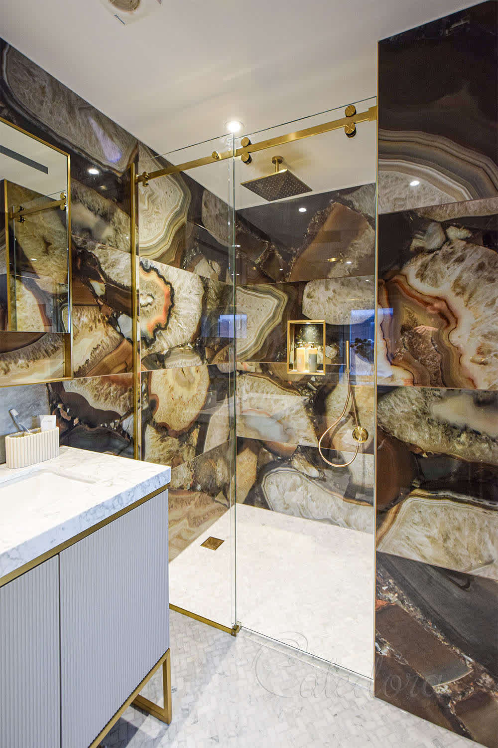 Luxury bathroom with brushed brass sliding shower door featuring ultra-clear glass and marble walls