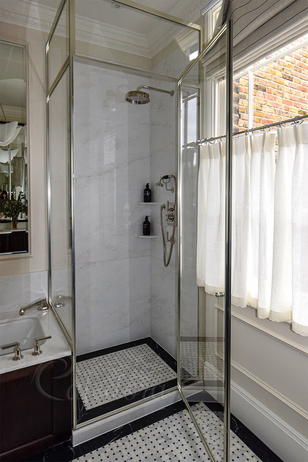 Framed nickel corner shower cubicle with Ultra Clear glass installed over bath edge
