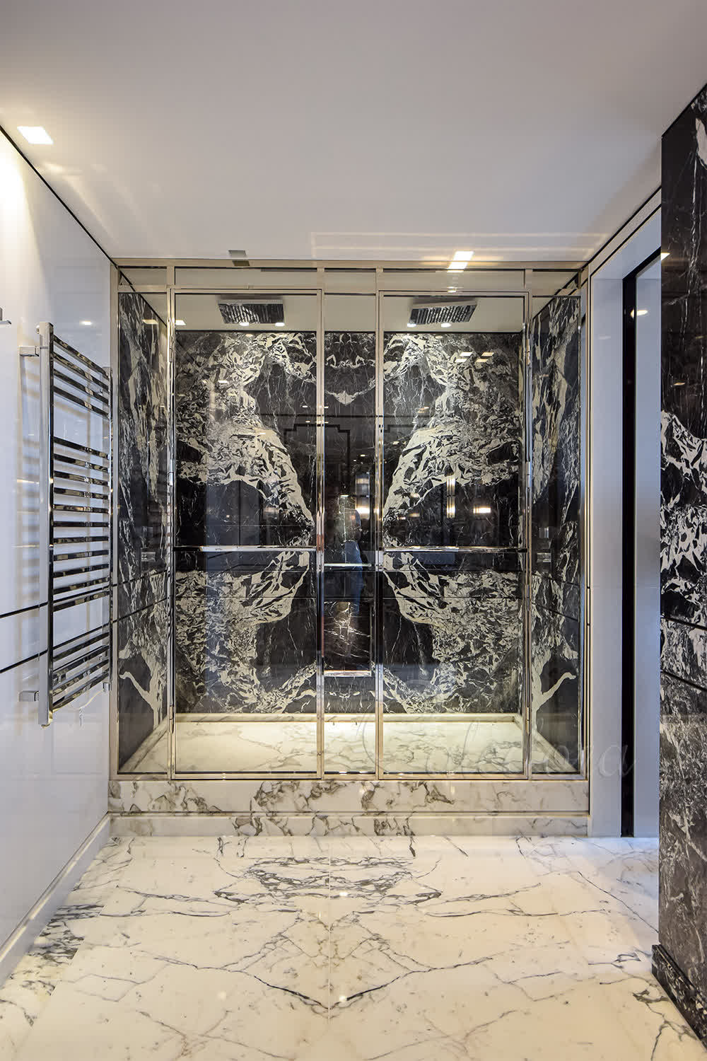 Wide opening double shower doors in polished nickel frame above tiled tray