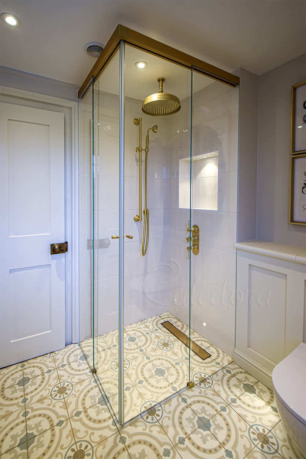 Corner entry sliding shower enclosure with satin brass finish and closed doors in Bath