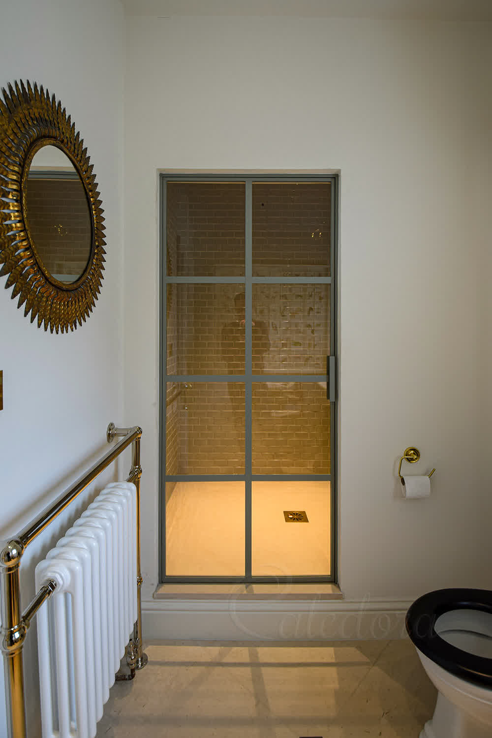 Light grey framed shower door with grid pattern shown closed in West Sussex bathroom
