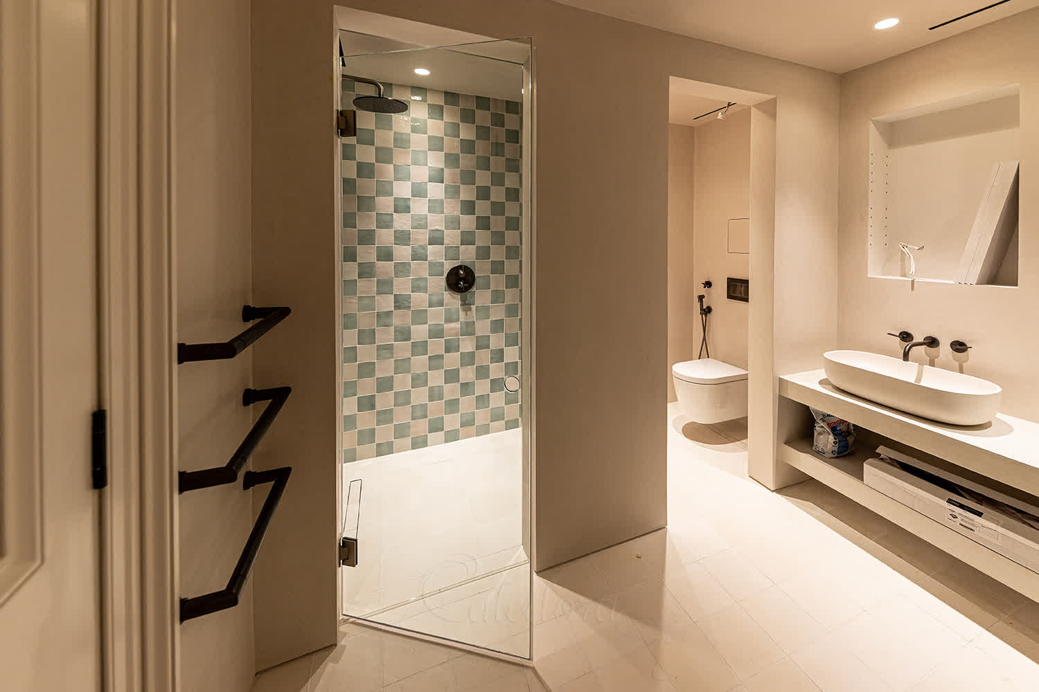 Frameless hinged shower door against microcement wall with invisible seals