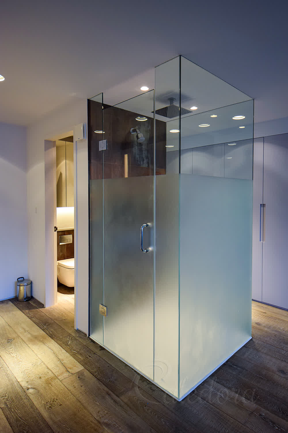 Three-sided frosted glass shower enclosure with sandblasted privacy section showing clear view at top in London home