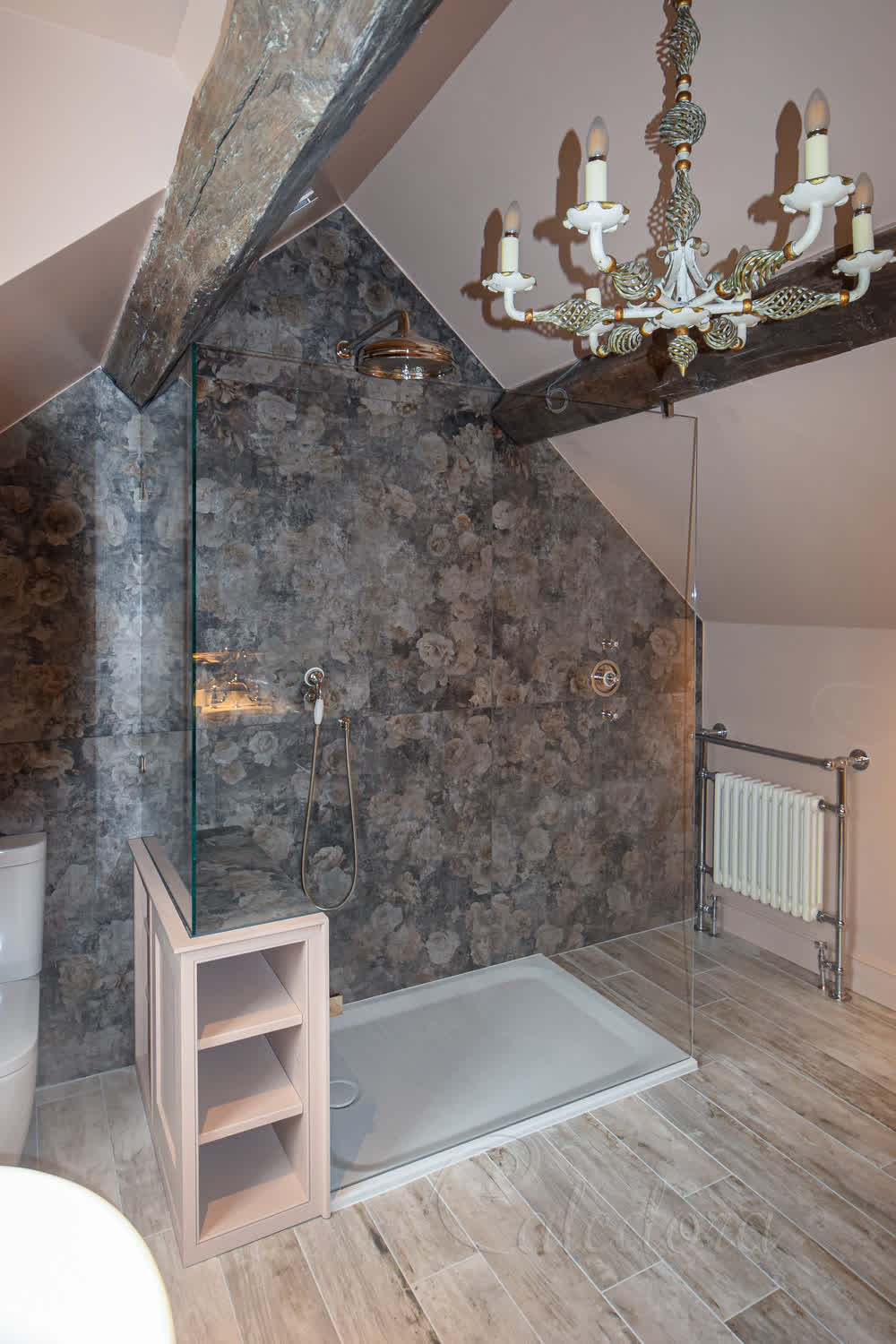 L-shaped frameless shower screen with nickel fittings in a loft bathroom with sloped ceiling