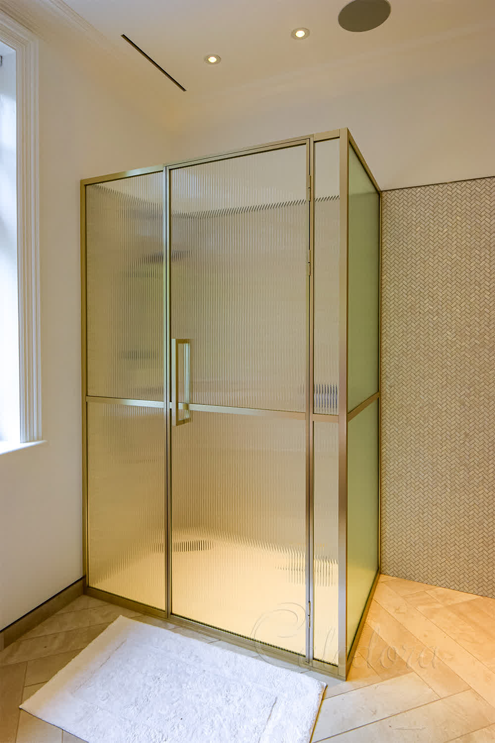 Framed bright gold corner shower enclosure with reeded glass panels in London bathroom