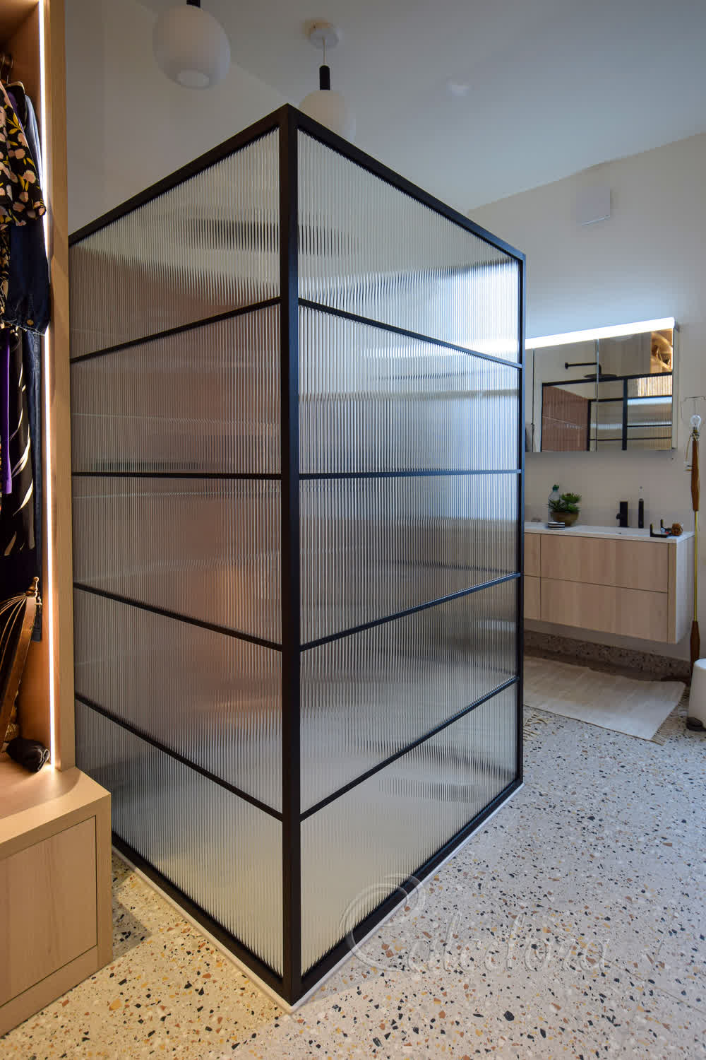 Three-sided black framed shower screen with reeded glass in London bathroom