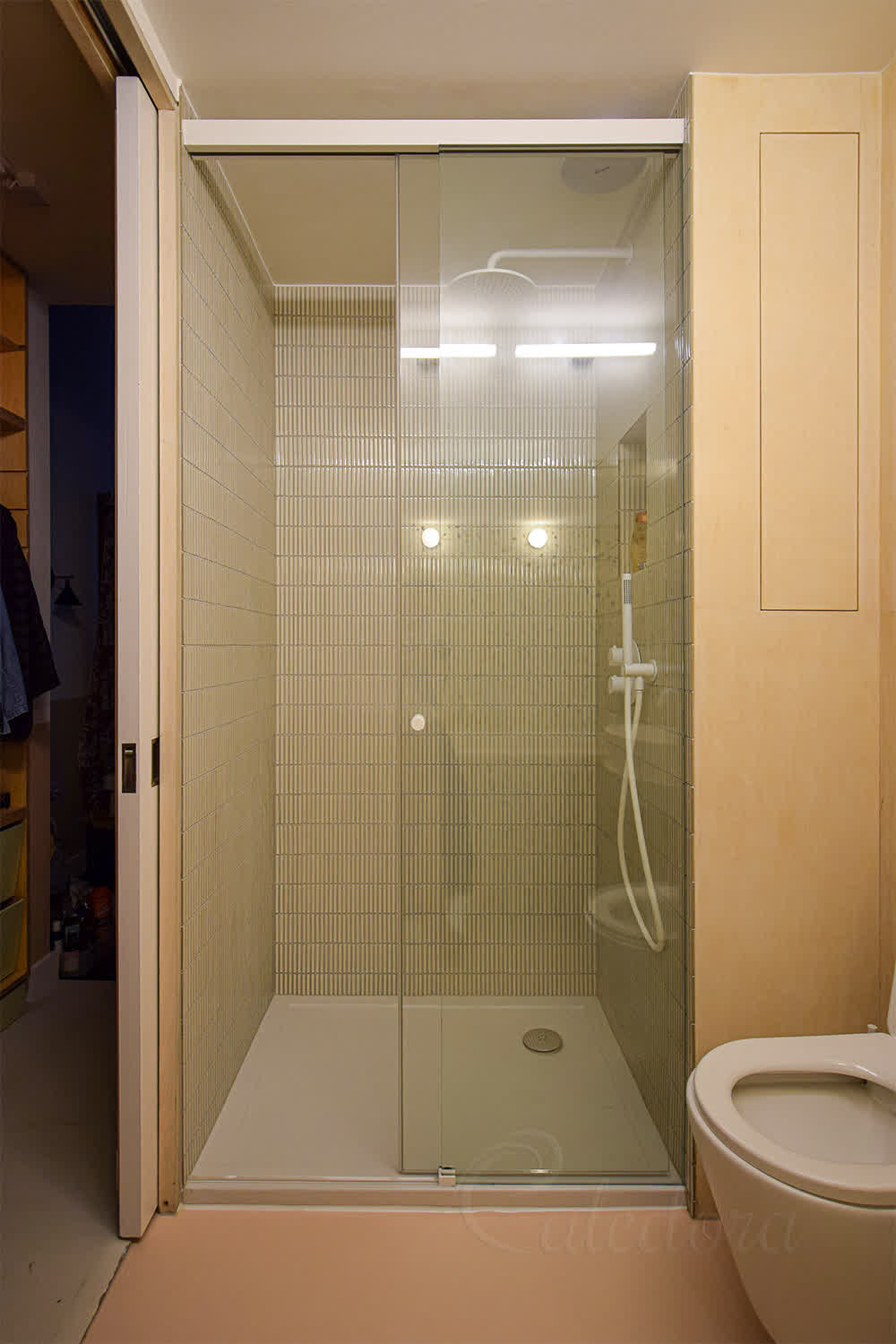 Frameless white sliding shower door with clear glass and minimal seals