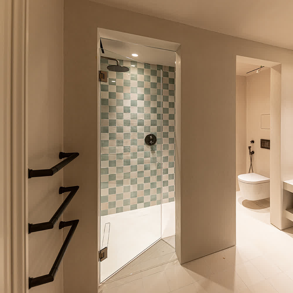 frameless hinged shower door with nickel hardware in a walk-in bathroom