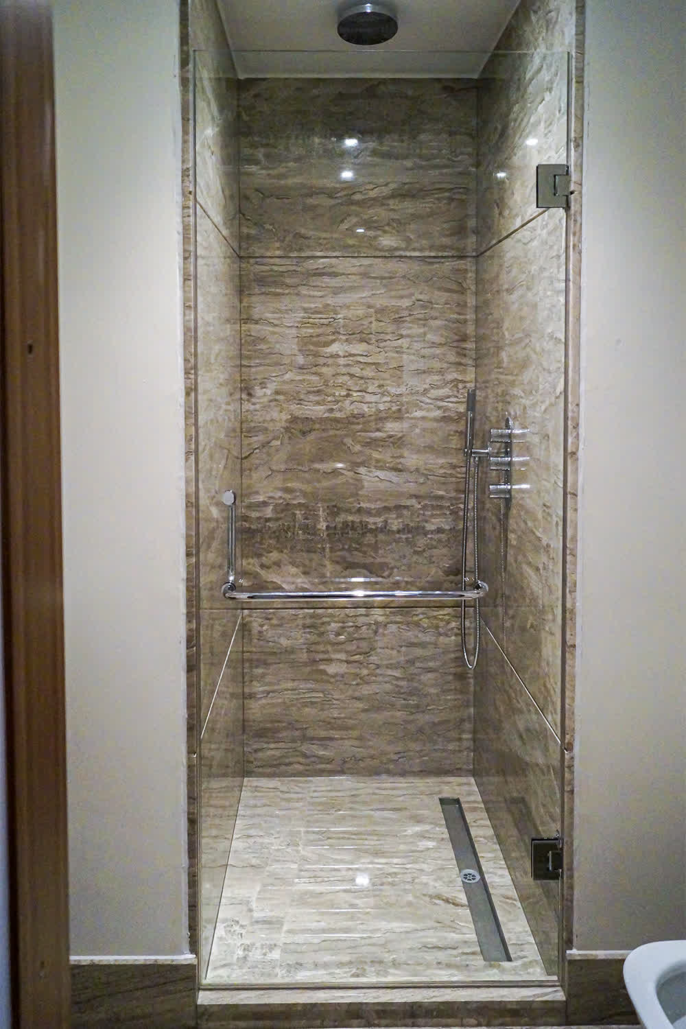 hinged shower door with a towel rail
